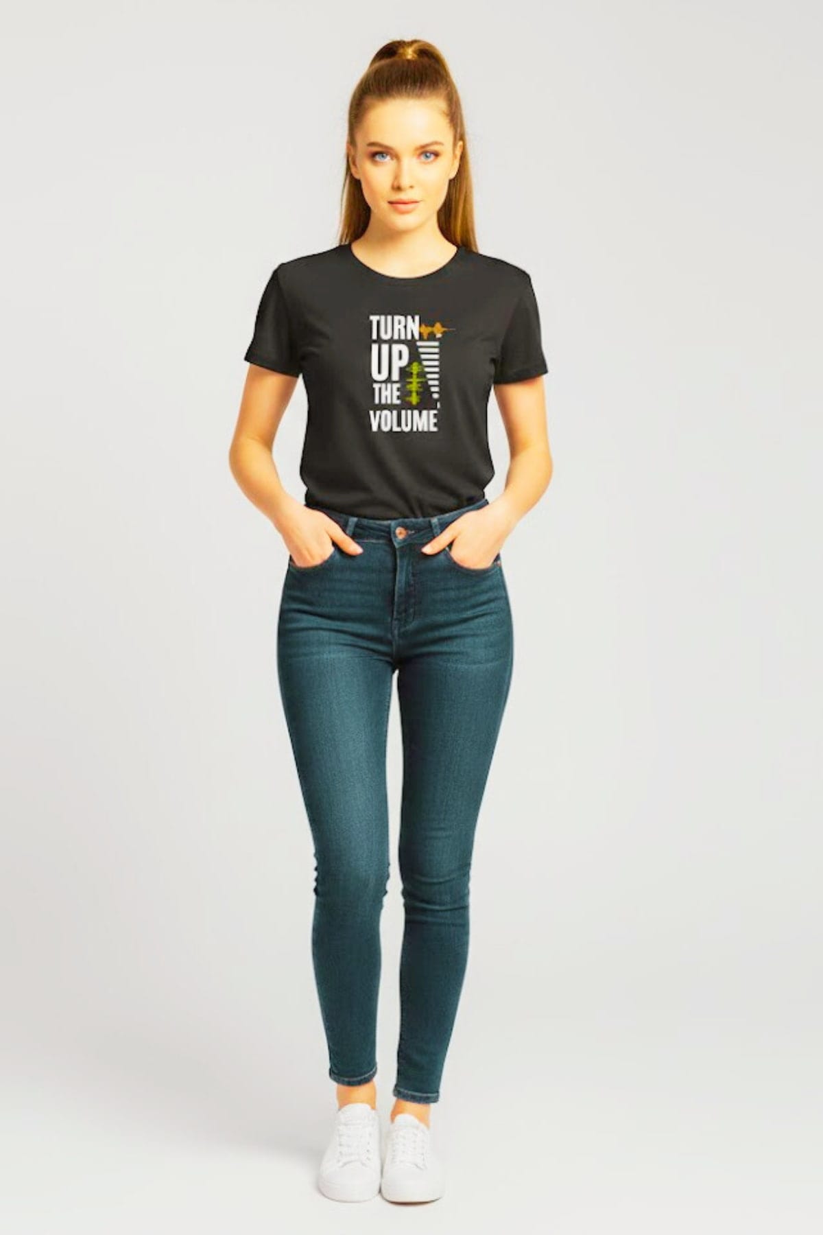 23-year-old woman wearing a Turn Up The Volume soundwave audio graphic T-shirt, full-body view, confident modern look