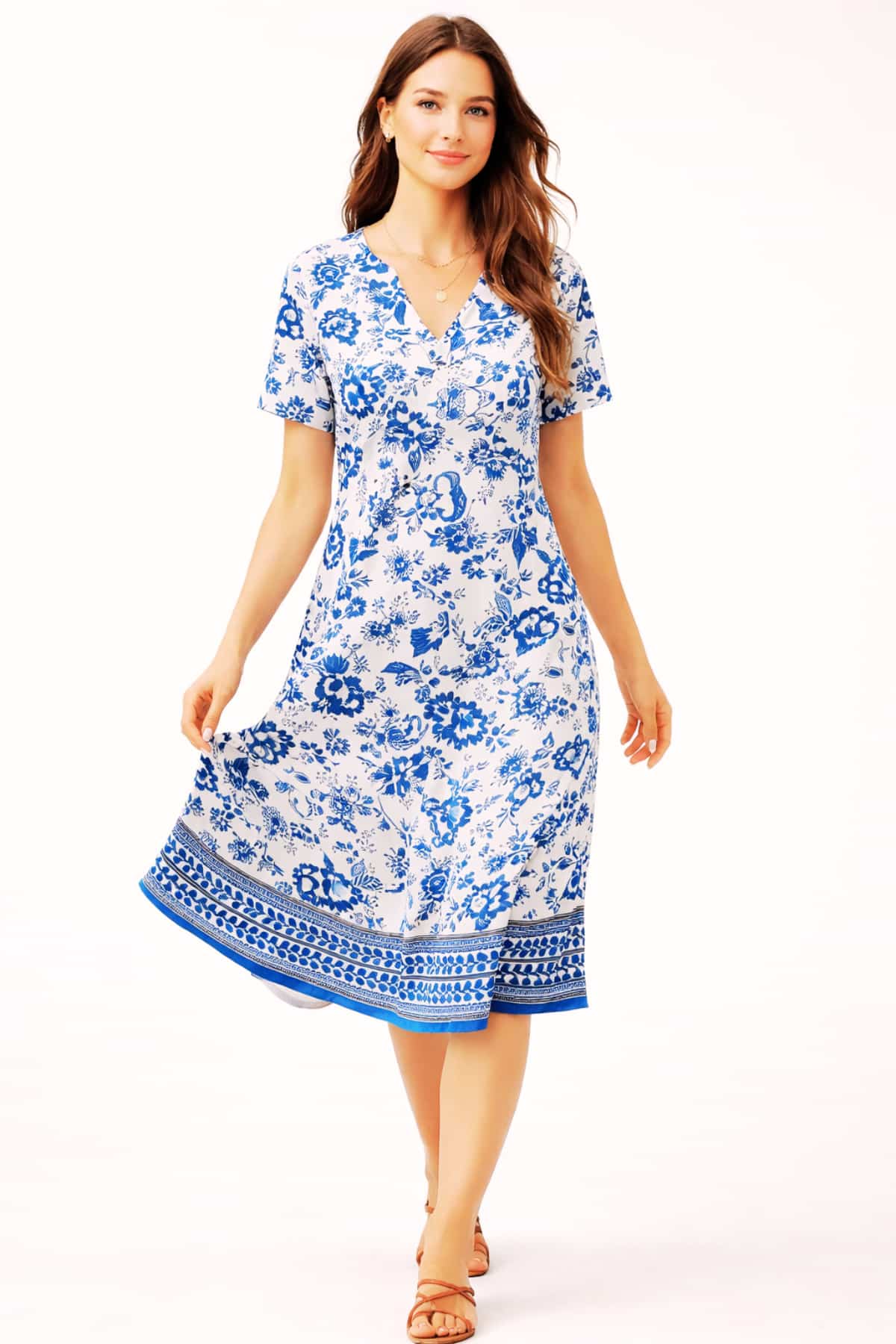 Blue and white floral women’s summer dress with short sleeves and V-neck — worn by a beautiful 23-year-old woman with very fair natural skin, bright blue eyes, brown silky hair, fit toned body, peaceful confident expression, casual knee-length sundress