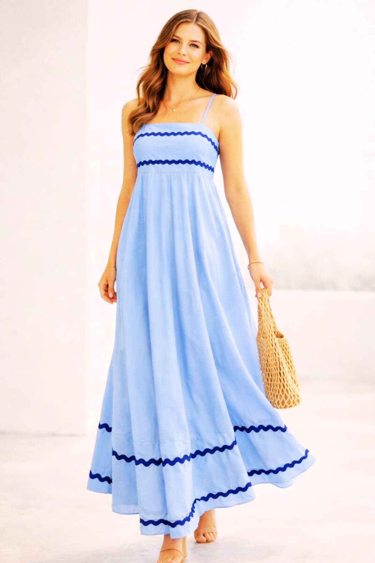 Light blue women’s summer maxi dress with spaghetti straps — worn by a beautiful 23-year-old woman with very fair natural skin, bright blue eyes, brown silky hair, fit toned body, peaceful confident expression, flowy sleeveless maxi dress for summer
