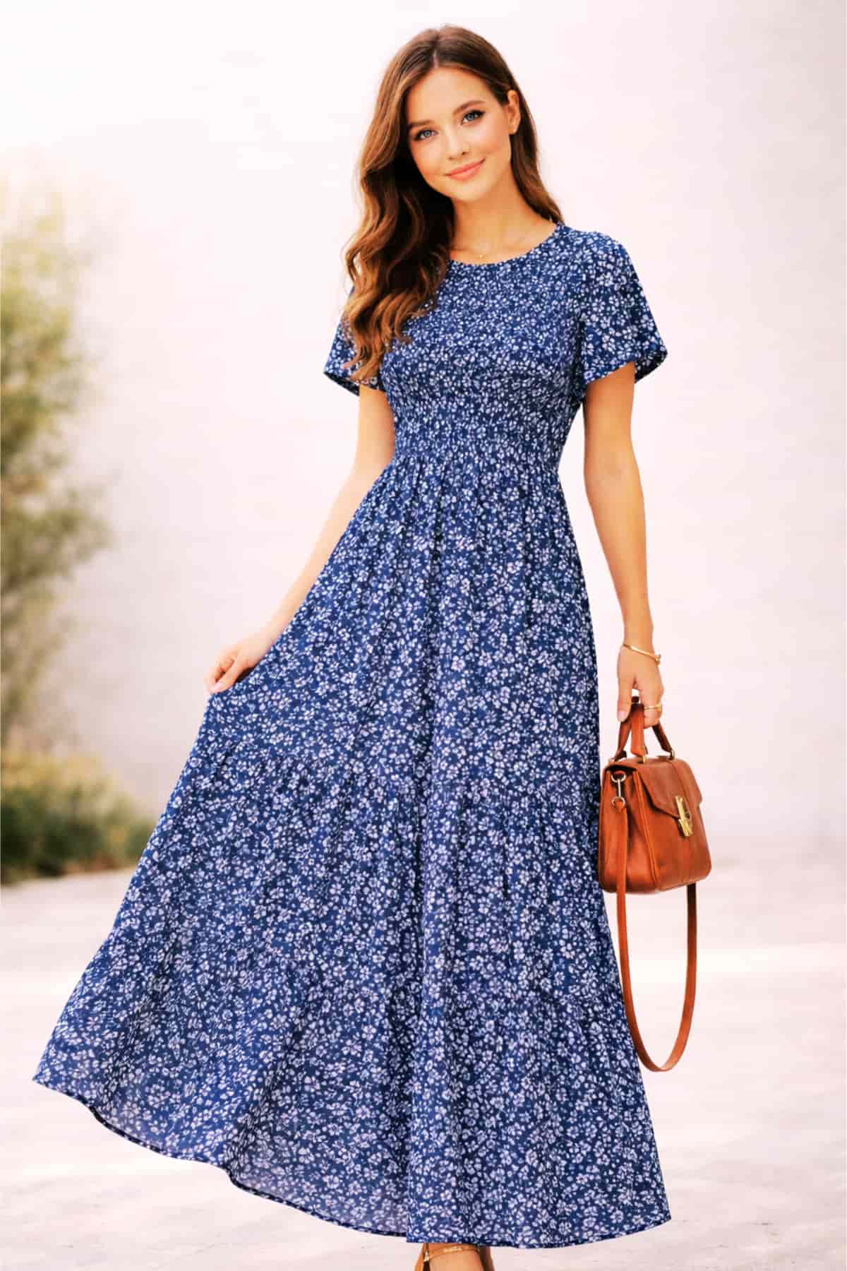 Navy floral women’s summer maxi dress with short sleeves and smocked waist — worn by a beautiful 23-year-old woman with very fair natural skin, bright blue eyes, brown silky hair, fit toned body, peaceful confident expression, flowy casual maxi dress