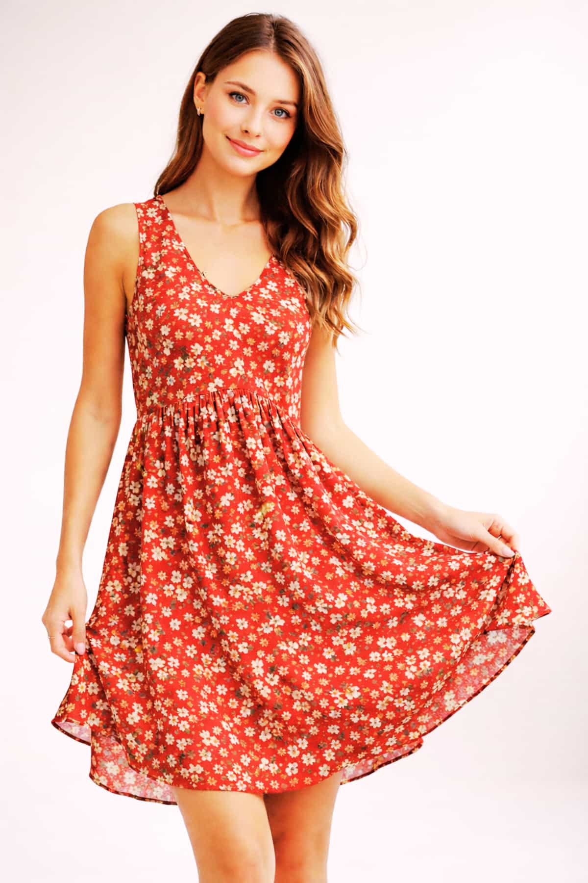 Red floral women’s summer dress sleeveless — worn by a beautiful 23-year-old woman with very fair natural skin, bright blue eyes, brown silky hair, fit toned body, peaceful confident expression, lightweight casual sundress for warm weather